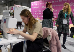 Uczennica technikum na stoisku tragowym Międzynarodowych Targów Tekstylnych Fast Textile.