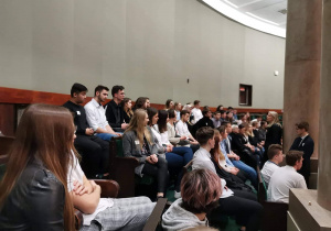 Uczniowie obserwują Salę Posiedzeń Sejmu z galerii.