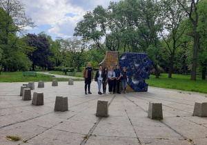 Uczestnicy wycieczki pozują do zdjęcia przy zegarze słonecznym w Parku Staromiejskim w Łodzi