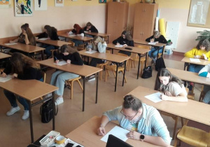Uczniowie siedzą w ławkach szkolnych, uzupełniają test wiedzy o Francji