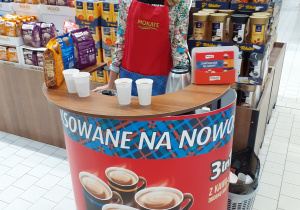 Uczennica technikum handlowego na stoisku do promocji sprzedaży kawy w hipermarkecie